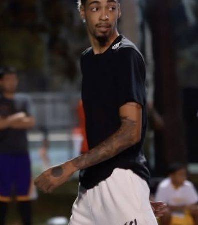 Athlete mid-stride in a black tee at an outdoor game