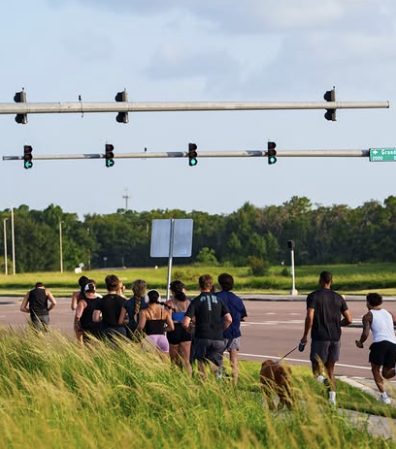 Run club group jogging along a road at golden hour